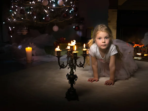 Una bambina in una stanza buia a lume di candela. — Foto Stock