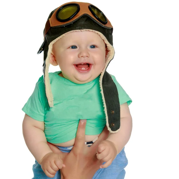 A little boy in a pilots cap and a wooden plane in his hand — Stock Photo, Image