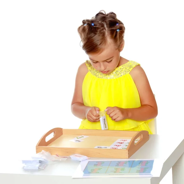 A little girl is studying Montessori stuff. — Stock Photo, Image