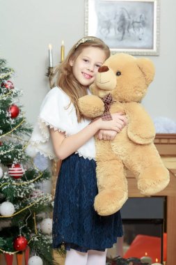 şömine yakın bir oyuncak ayı ile küçük kız.