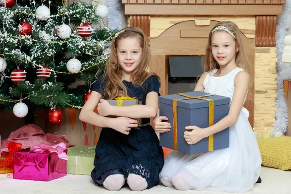 Mädchen Zwillinge mit Geschenken und Weihnachtsbaum. — Stockfoto