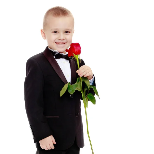Liten pojke med en ros blomma. — Stockfoto