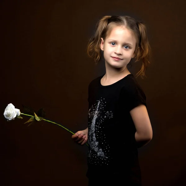 Liten flicka med en blomma i handen. — Stockfoto