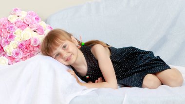 Bir buket çiçek kanepenin üstünde küçük kız