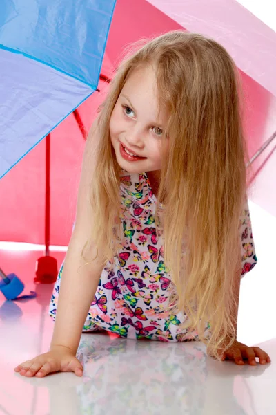 Little girl under an umbrella. — Stock Photo, Image