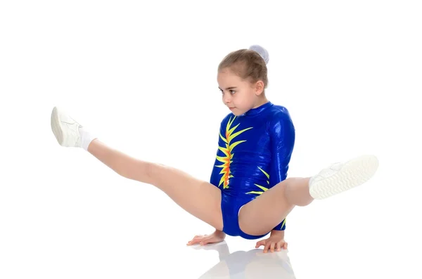 Una chica gimnasta realiza ejercicios en el suelo . —  Fotos de Stock