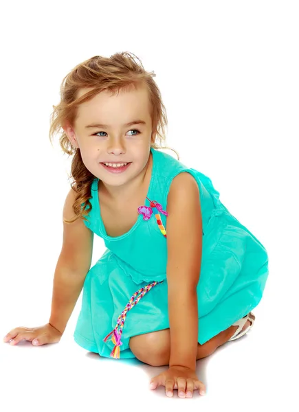 Dziewczynka w niebieskiej sukience na jej kolanach — Zdjęcie stockowe