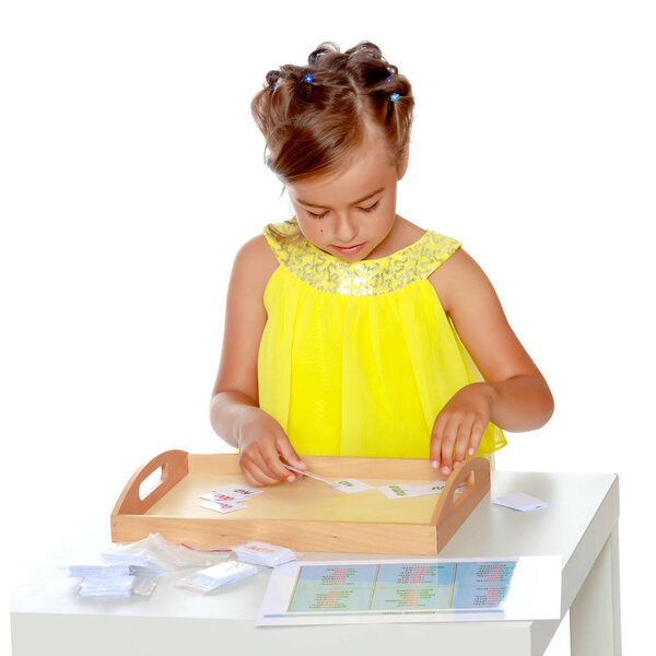 Маленькая девочка изучает вещи Монтессори..
