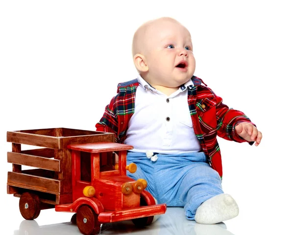 A little boy is playing with a toy car. — Stock Photo, Image