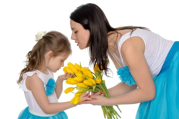 Mutter und Tochter riechen gelbe Tulpen. — Stockfoto