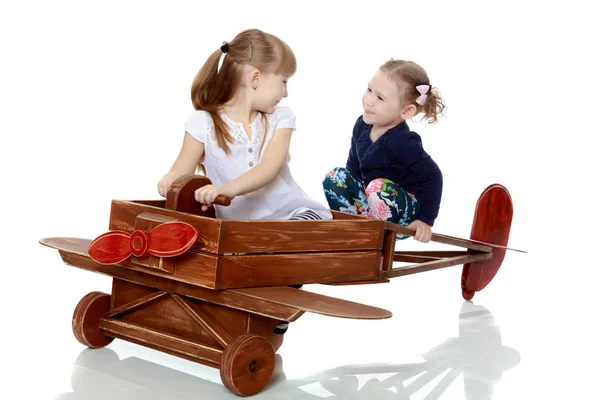Δύο αδελφές, παίζοντας με ένα ξύλινο αεροπλάνο — Φωτογραφία Αρχείου