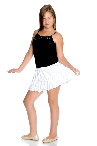 Een tienermeisje in een korte witte rok en een zwarte T-shirt. — Stockfoto