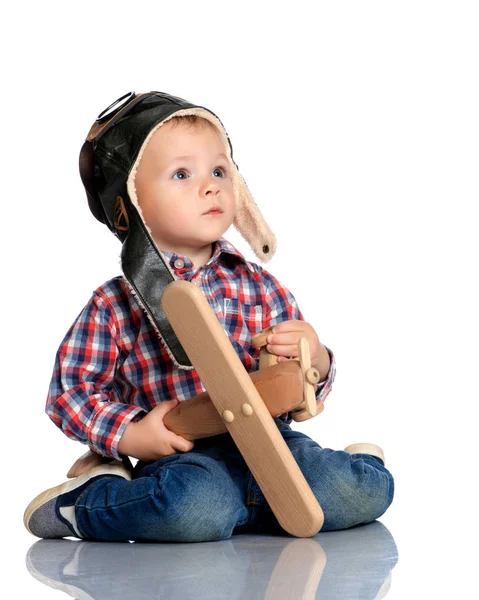 一个小男孩在飞行员帽，手里的木制飞机 — 图库照片