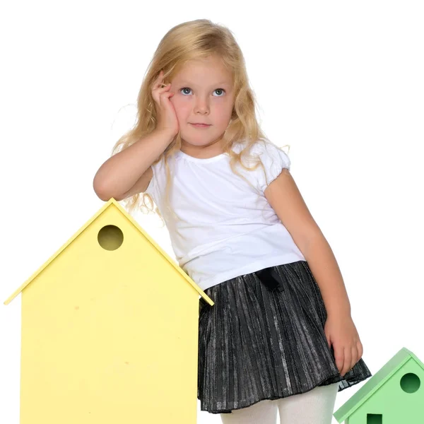 Niña está jugando con casas de madera . — Foto de Stock