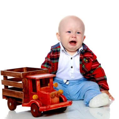 Küçük bir çocuk oyuncak bir arabayla oynuyor..