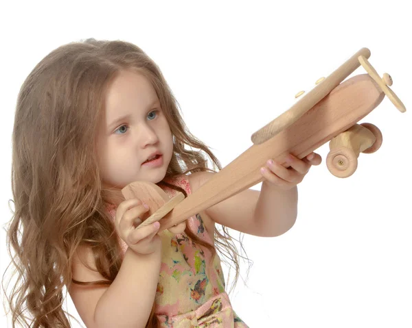 Little girl is playing with a plane — Stock Photo, Image