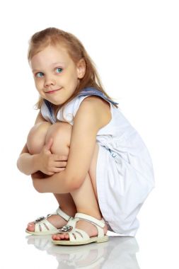 Küçük kız yerde oturuyor..