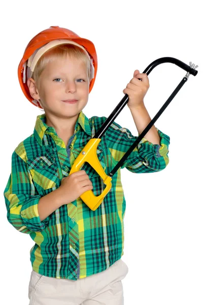 Un niño pequeño en un casco de trabajadores de la construcción está sosteniendo un inst — Foto de Stock