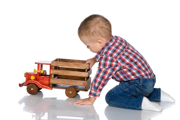 A little boy is playing with a toy car. — Stock Photo, Image