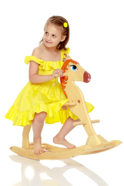 Chica balanceándose en un caballo de madera . — Foto de Stock