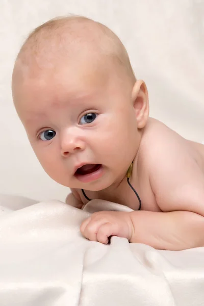 Een charmante baby kijkt naar de camera. — Stockfoto