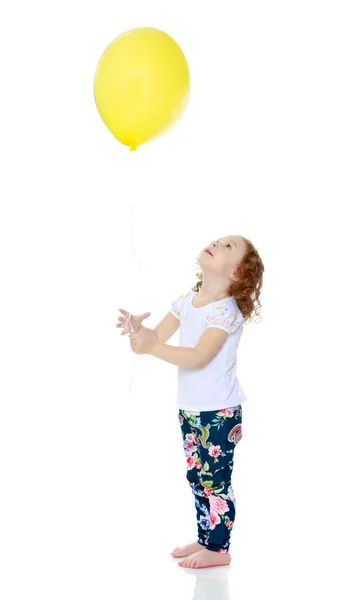 Menina está brincando com um balão — Fotografia de Stock