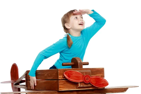 Das Mädchen spielt mit einem großen Spielzeugflugzeug. — Stockfoto