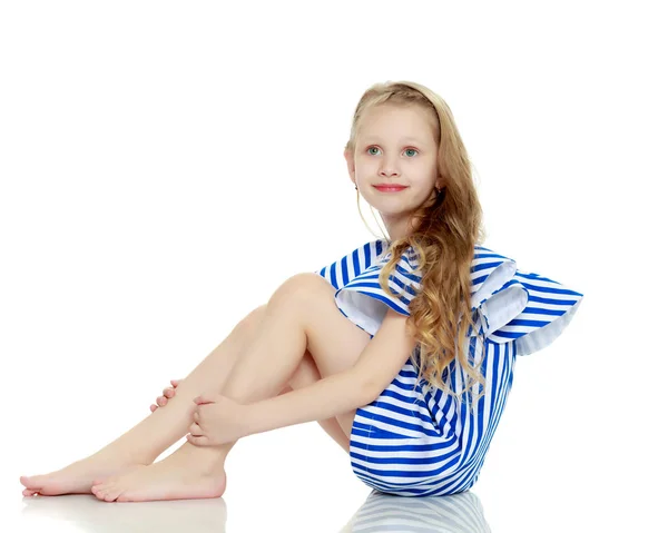 Roztomilá blonďatá holčička ve velmi krátké letní pruhované šaty. — Stock fotografie