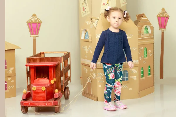 Niña está jugando con un coche de madera . —  Fotos de Stock