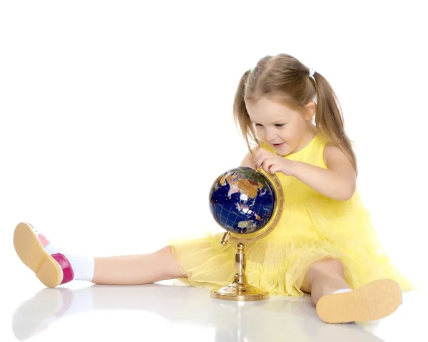 A little girl looks at the Globe. — Stock Photo, Image