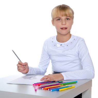 Küçük bir kız masada çizim.