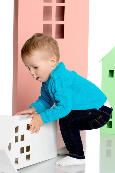 Un petit garçon joue avec des maisons colorées . — Photo