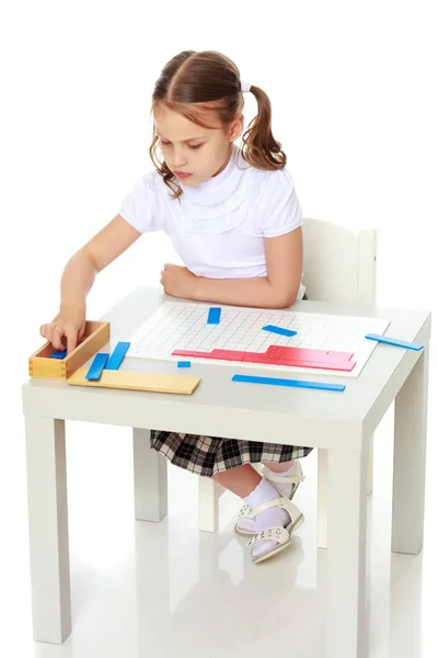 Een klein meisje studeert Montessori dingen.. — Stockfoto