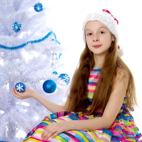 एक लहान मुलगी ख्रिसमस ट्री सजावट करीत आहे . — स्टॉक फोटो, इमेज