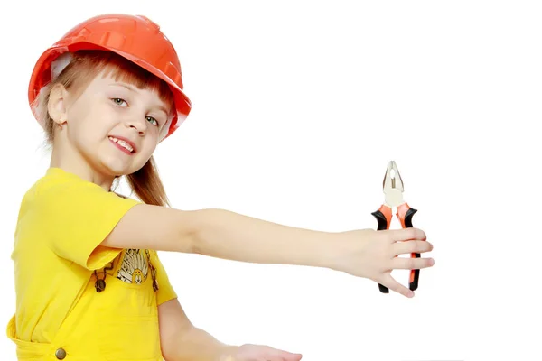 Menina em um capacete de construção espreita por trás de um outdoor . — Fotografia de Stock