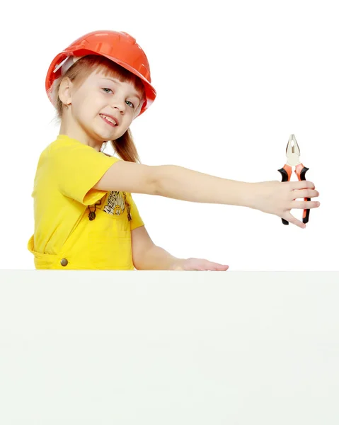 Mädchen mit Bauhelm guckt hinter einer Werbetafel hervor. — Stockfoto