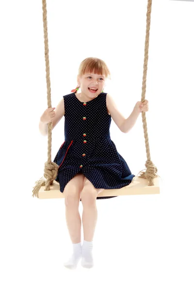 Klein meisje swingen op een swing — Stockfoto