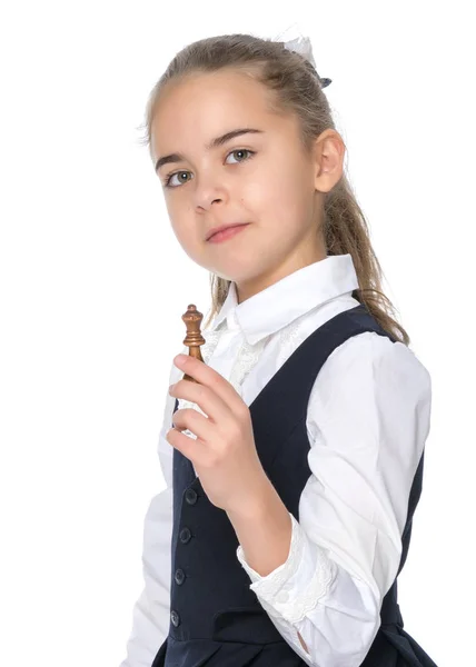 Den lilla flickan håller en schackpjäs i handen. — Stockfoto