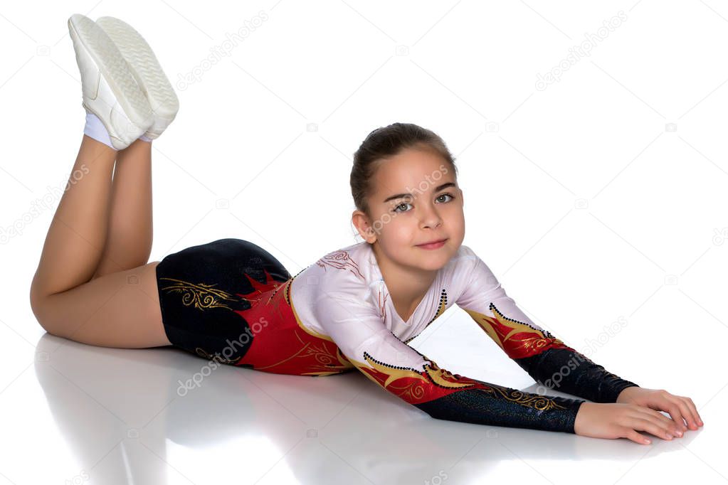 The little gymnast perform an acrobatic element on the floor.
