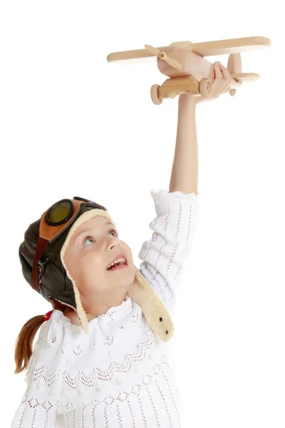 Little girl with a wooden plane in her hand. — Stock Photo, Image