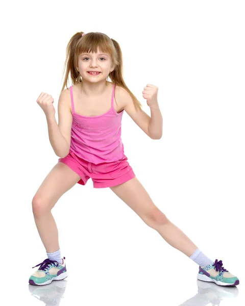 Ein kleines Mädchen zeigt ihre Muskeln. — Stockfoto