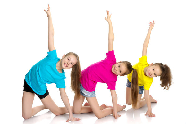 A group of girls gymnasts perform exercises.