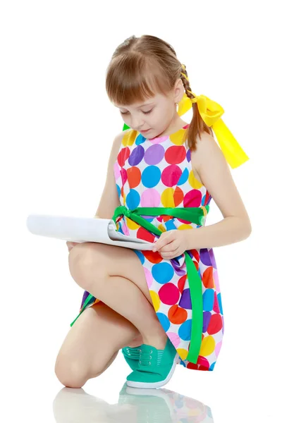 Malá holčička čte brožury. — Stock fotografie