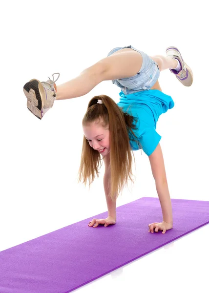 Girl gymnast performs a handstand. — Stock Photo, Image