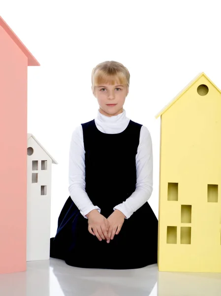 Little girl is playing with wooden houses. — Stock Photo, Image