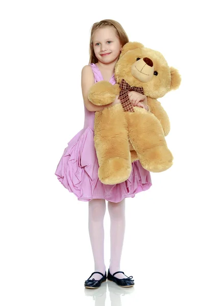 Belle petite fille 5-6 ans.Elle tient un grand bea en peluche — Photo