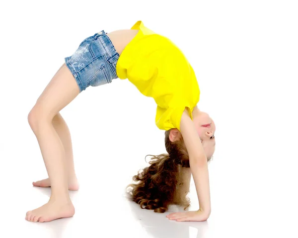 The little gymnast performs a bridge. — Stock Photo, Image