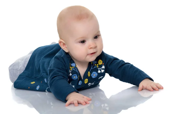 Een leuk, zeer weinig meisje ligt op de vloer op een witte backgr — Stockfoto