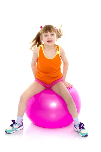Küçük bir kız büyük spor salonu topa atlıyor. — Stok fotoğraf