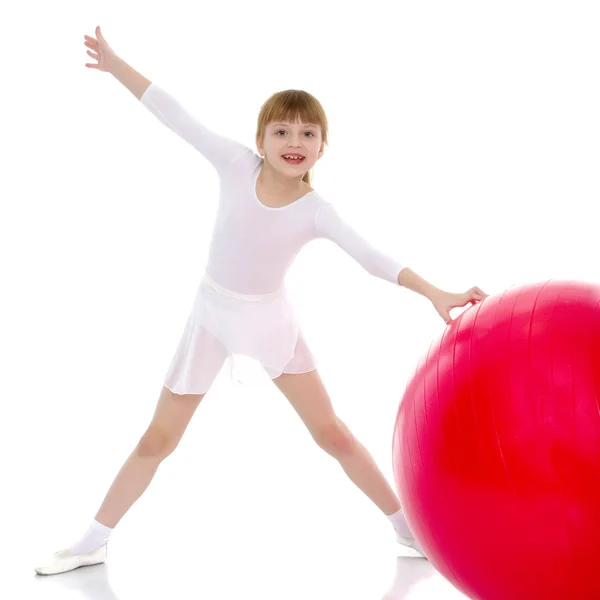 Kleines Mädchen macht Übungen auf einem großen Ball für Fitness. — Stockfoto